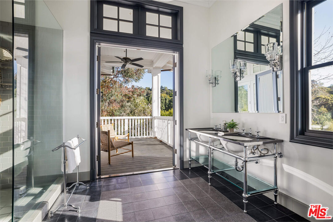 9779 Oak Pass Road Beverly Hills, CA 90210 - Photo 27 of 43 a bathroom with a sink a toilet a mirror and next to a window