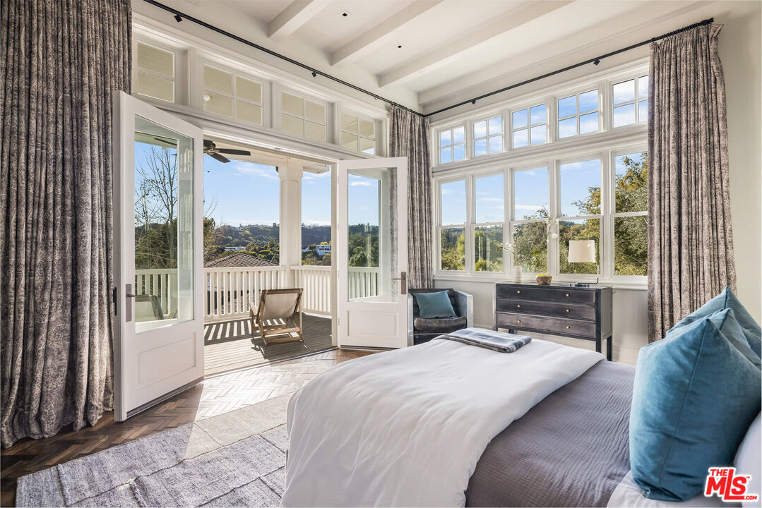 9779 Oak Pass Road Beverly Hills, CA 90210 - Photo 28 of 43 a spacious bedroom with a large bed and a large window