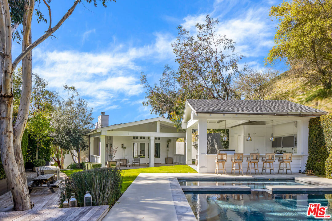 9779 Oak Pass Road Beverly Hills, CA 90210 - Photo 32 of 43 a view of a house with swimming pool and sitting area