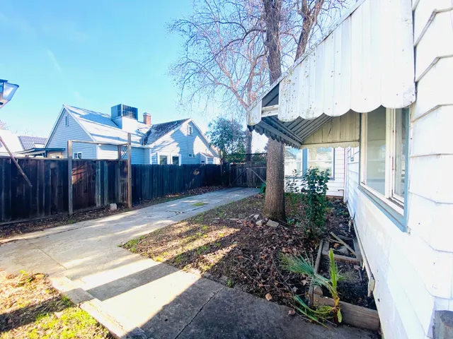 a view of a house with wooden fence next to a road