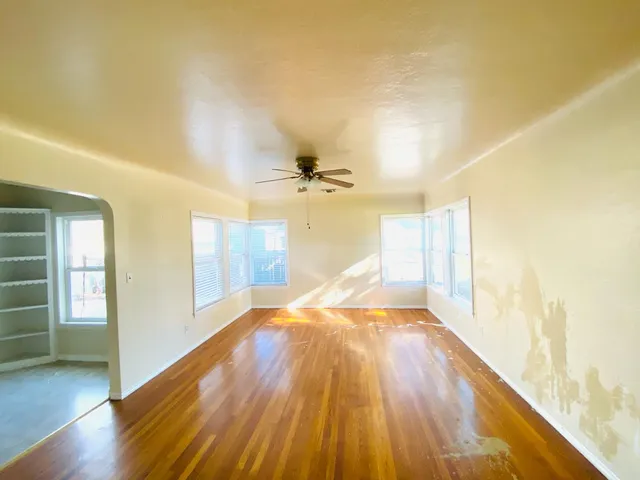 a view of a big room with wooden floor and windows