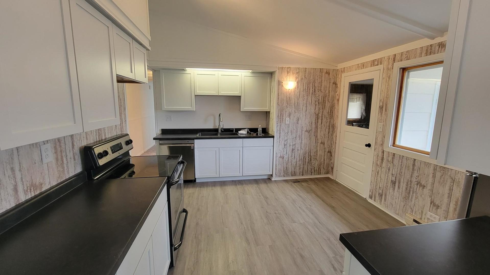 146 Center Street Seneca, IL 61360 - Photo 5 of 19 a kitchen with granite countertop a sink a stove cabinets and wooden floor