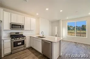 a kitchen with a sink stove top oven and cabinets