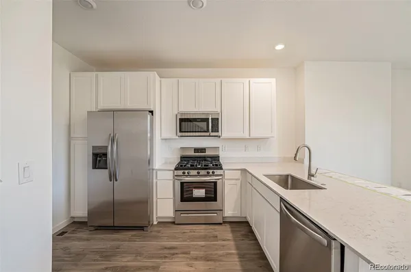 a kitchen with white cabinets and stainless steel appliances