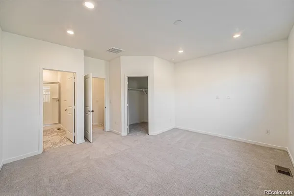 an empty room with closet and a bathroom