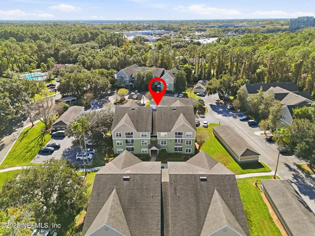 an aerial view of residential houses with outdoor space and ocean view