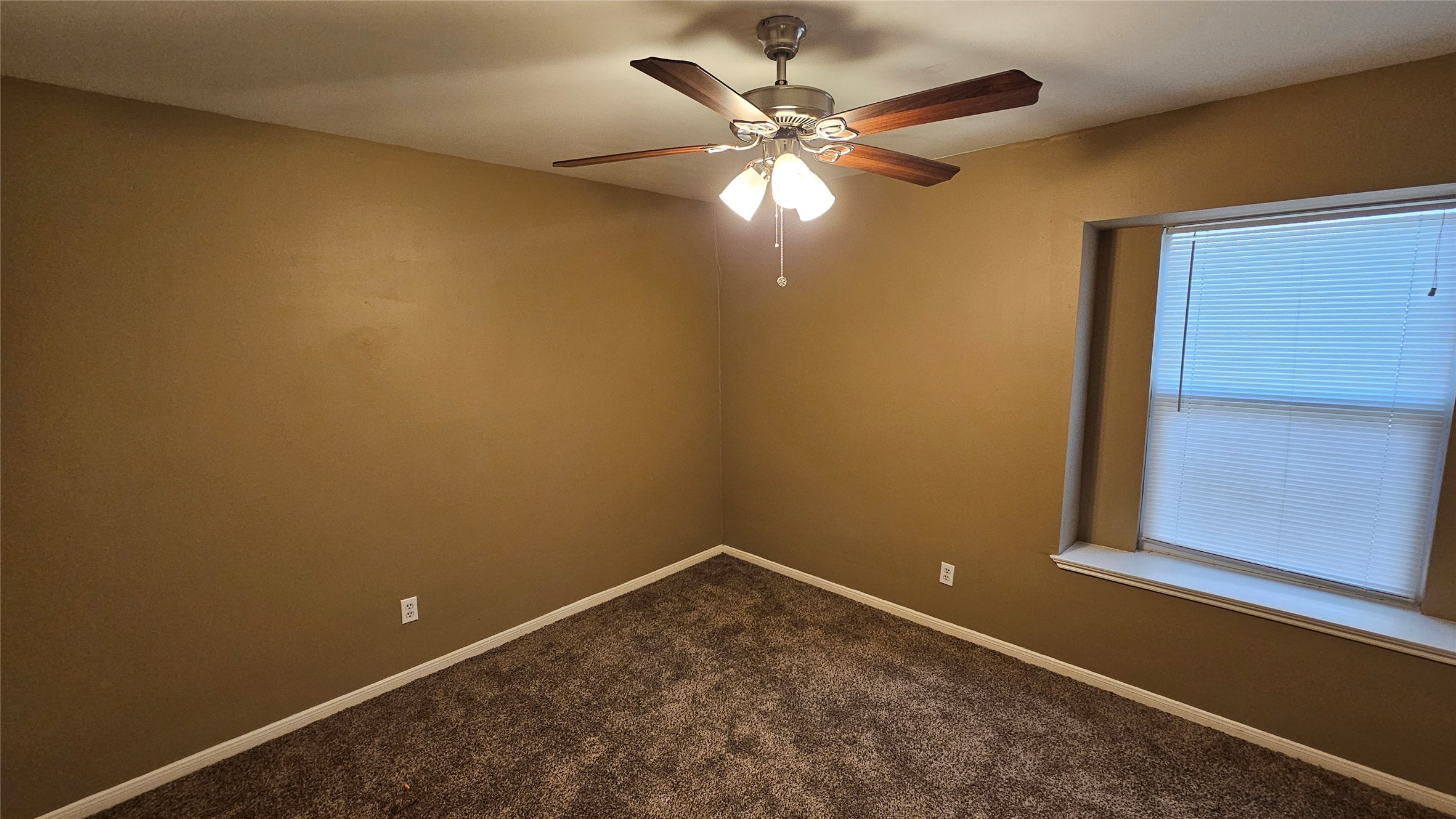 14807 Spring Lake Drive Houston, TX 77070 - Photo 11 of 21 an empty room with a chandelier fan and a window