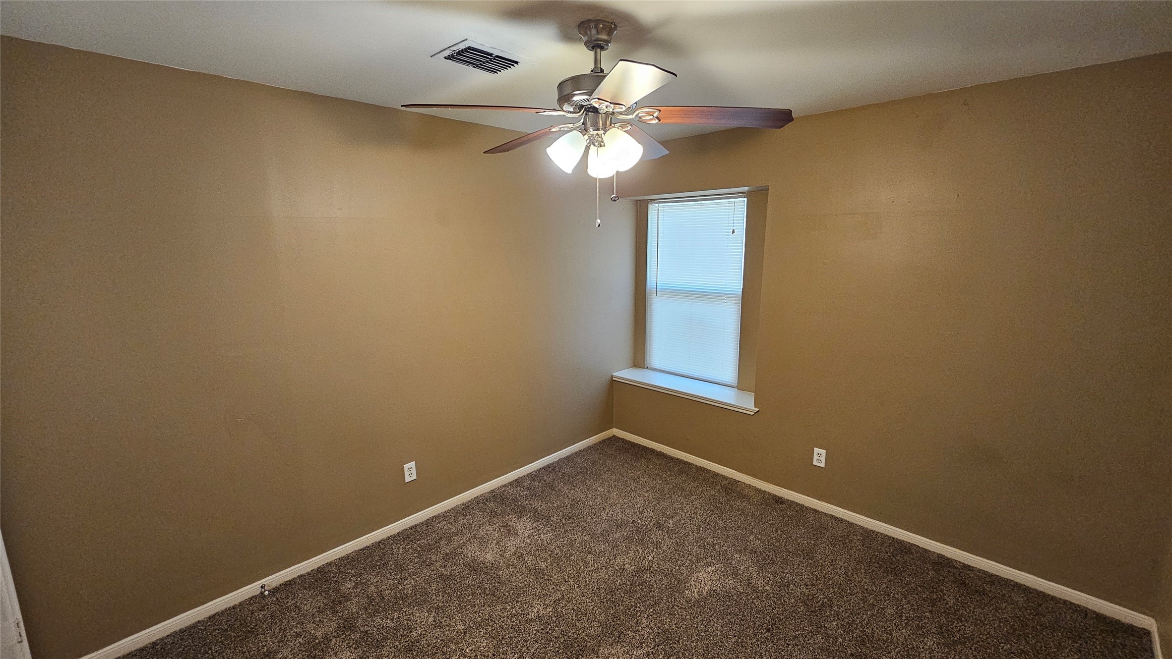 14807 Spring Lake Drive Houston, TX 77070 - Photo 12 of 21 an empty room with a window and a fan