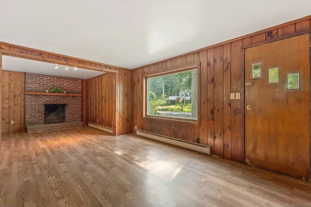 an empty room with windows fire place and an entryway