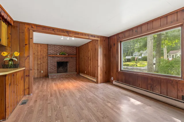 a view of an empty room with a fireplace and a window