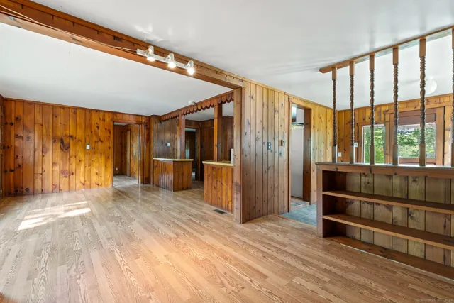a view of hallway with a large window and wooden floor