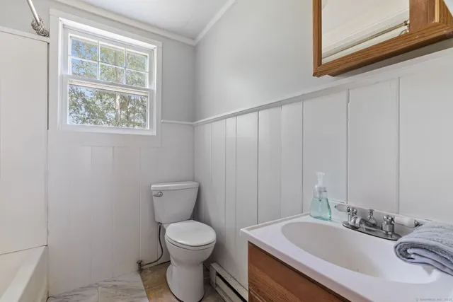 a bathroom with a toilet a sink and a window