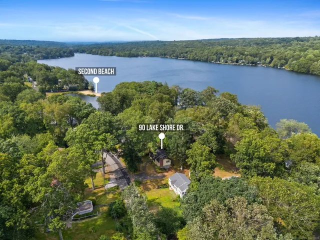 an aerial view of residential houses with outdoor space and trees