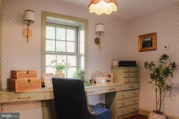a dining room with wooden floor and windows