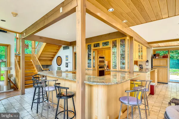 a kitchen with stainless steel appliances granite countertop a refrigerator sink stove and cabinets