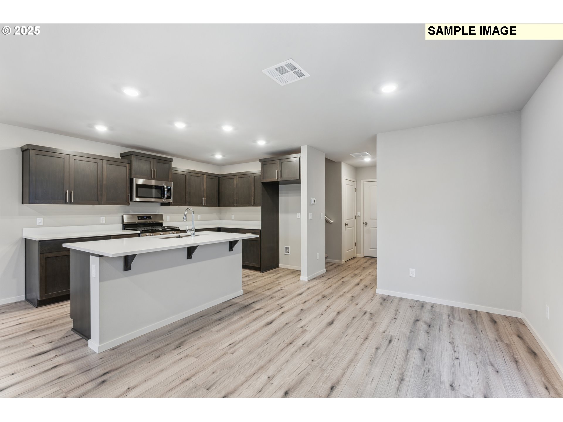 736 Merriott Lane Woodburn, OR 97071 - Photo 6 of 35 a large white kitchen with kitchen island a sink stainless steel appliances and cabinets