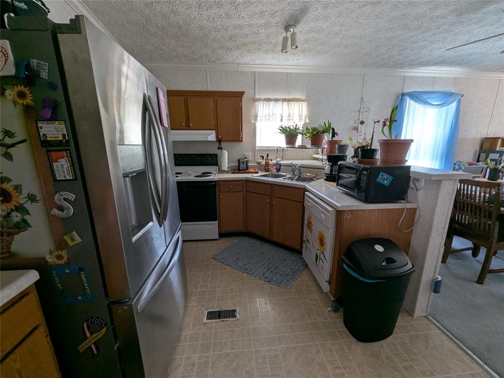 5139 Northeast Sandy Road Arcadia, FL 34266 - Photo 19 of 45 a kitchen with stainless steel appliances granite countertop a refrigerator a stove and a sink