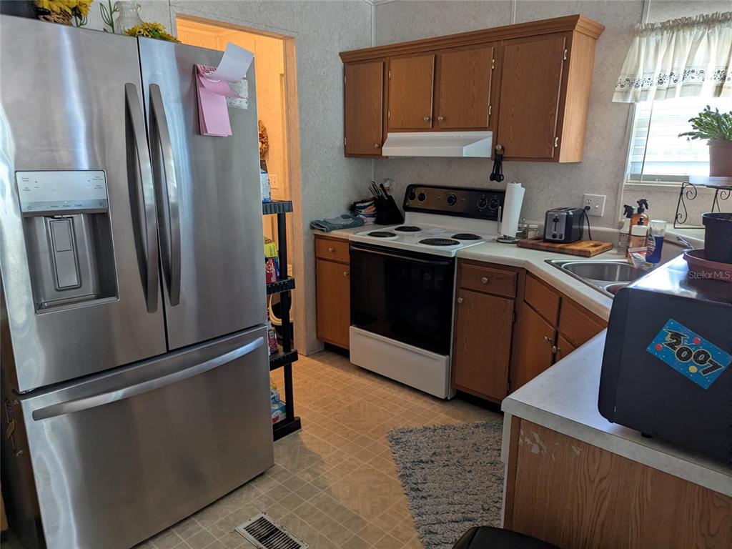 5139 Northeast Sandy Road Arcadia, FL 34266 - Photo 20 of 45 a kitchen with stainless steel appliances granite countertop a refrigerator a stove a sink and a refrigerator