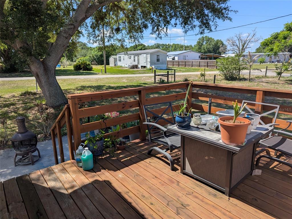 5139 Northeast Sandy Road Arcadia, FL 34266 - Photo 35 of 45 a view of a chairs and table on the deck with wooden floor
