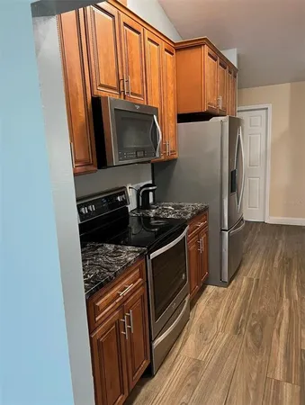a kitchen with stainless steel appliances granite countertop a stove a sink and a microwave