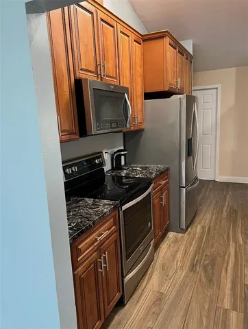 a kitchen with stainless steel appliances granite countertop a stove a sink and a microwave