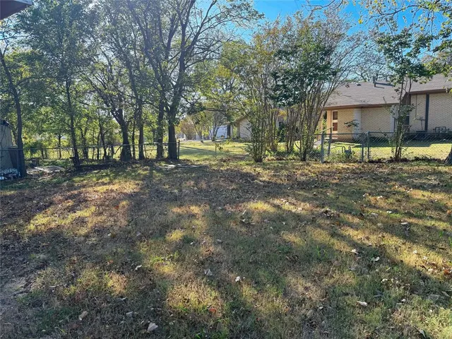 an empty room with wooden floor and a ceiling fan