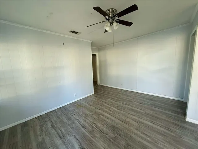 an empty room with a window and a ceiling fan