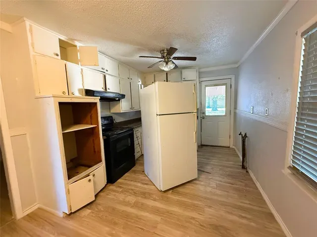 a kitchen with granite countertop a sink a stove and cabinets