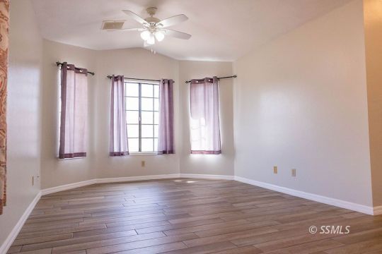 1012 Conejo Avenue Ridgecrest, CA 93555 - Photo 4 of 24 a view of an empty room with wooden floor and a window