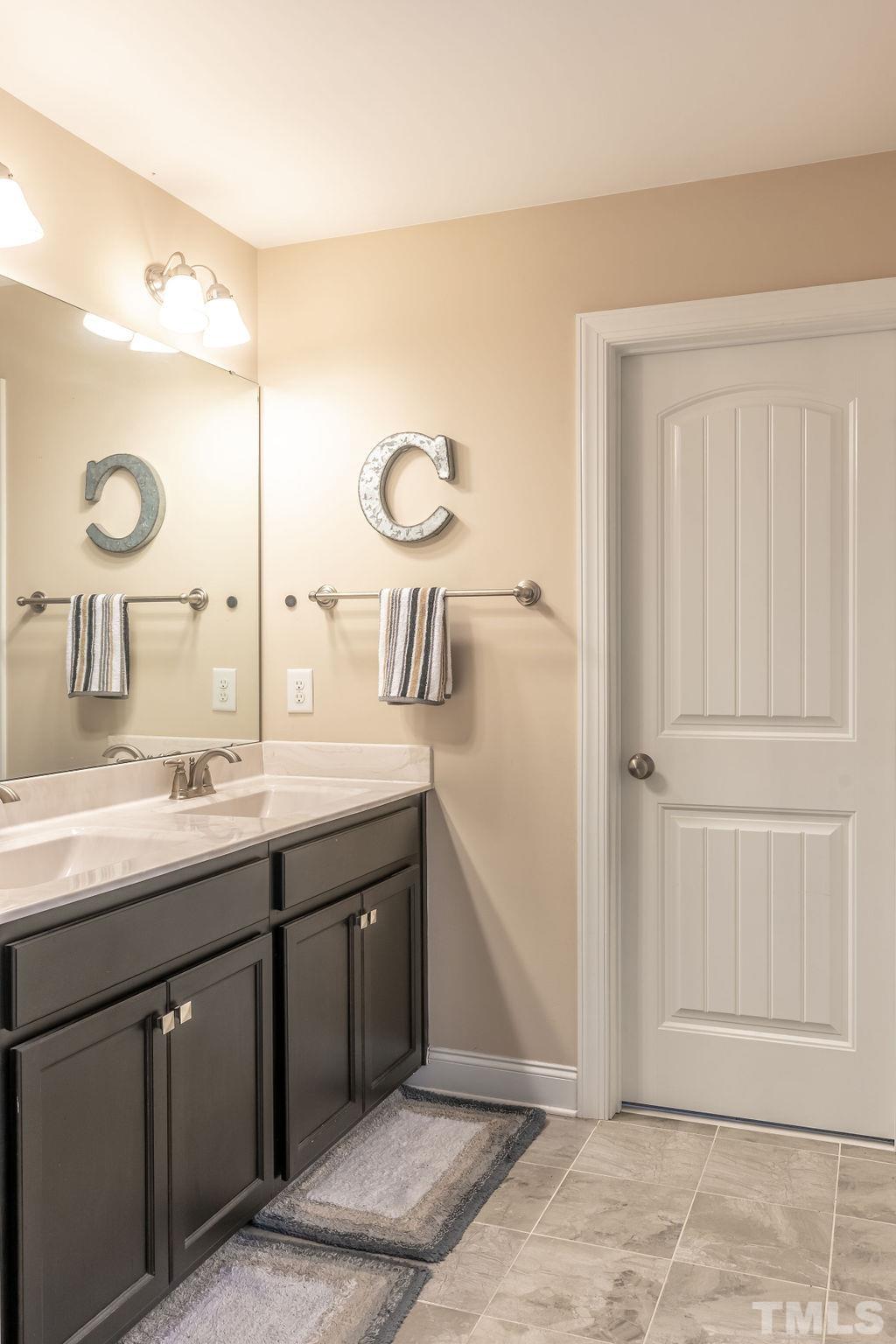 3578 Eastern Branch Road Raleigh, NC 27610 - Photo 16 of 24 a bathroom with a double vanity sink and a mirror
