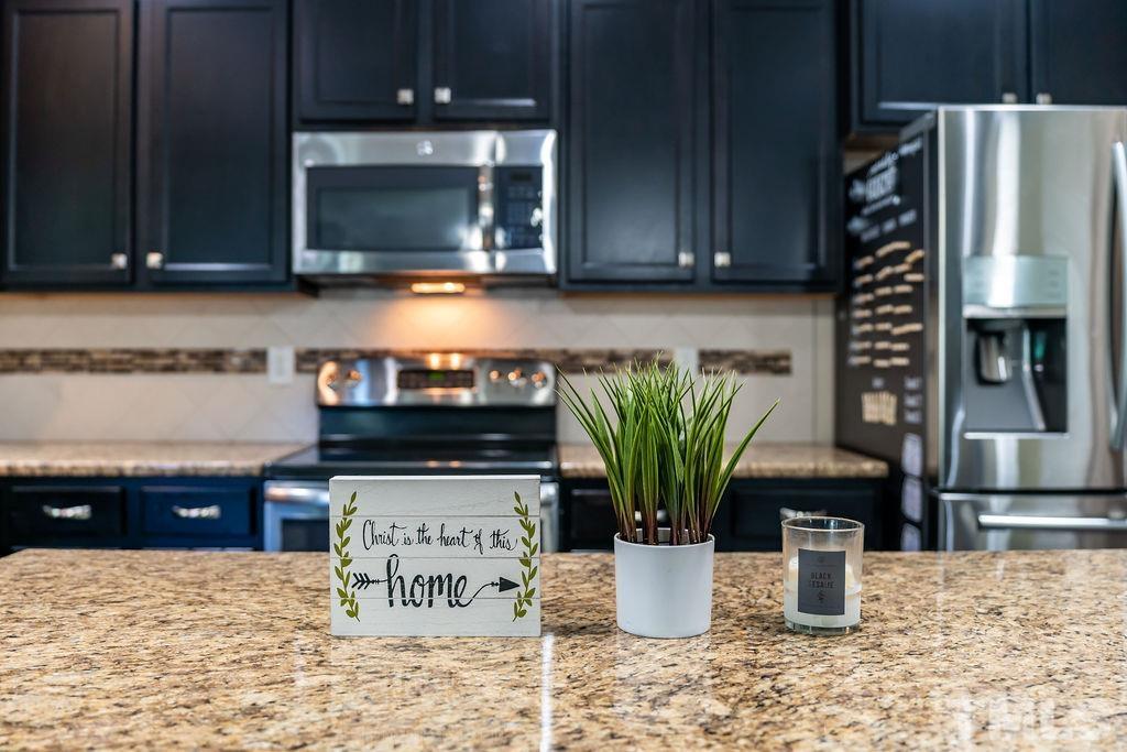 3578 Eastern Branch Road Raleigh, NC 27610 - Photo 7 of 24 a kitchen with a microwave a stove and cabinets
