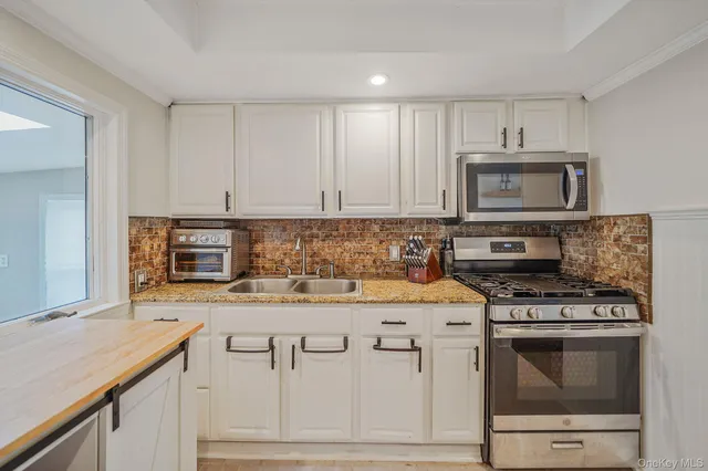 a kitchen with granite countertop a stove sink and cabinets