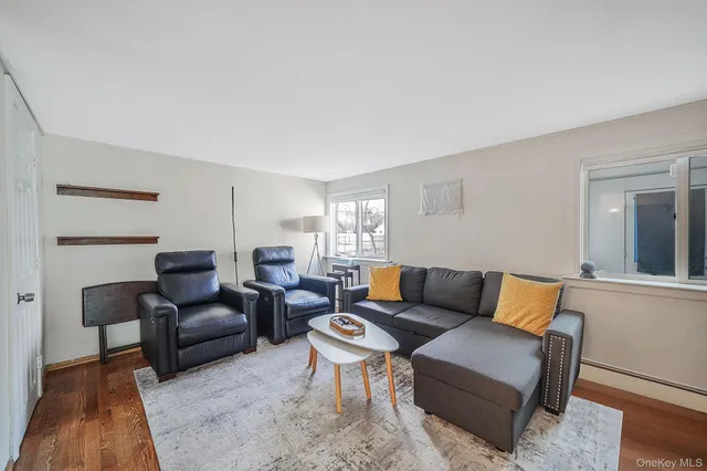 a living room with furniture wooden floor and a lamp