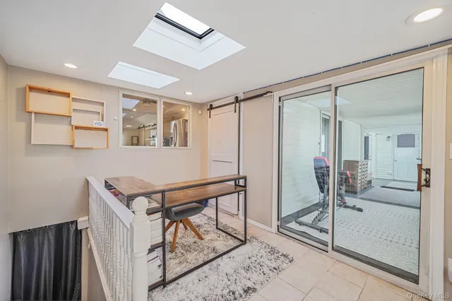 a room with a glass door shower and hallway