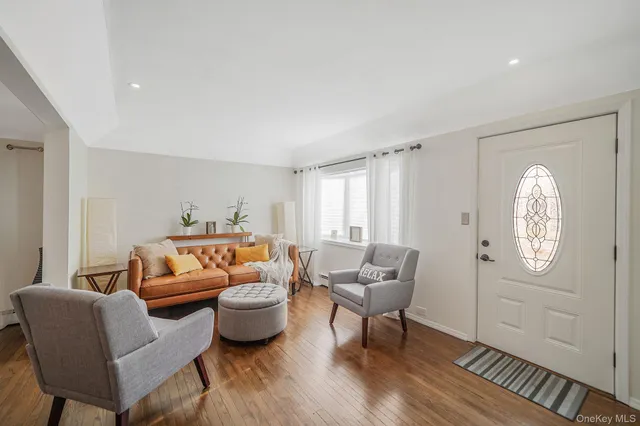 a living room with furniture mirror and wooden floor