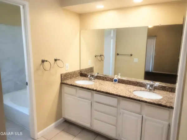 a bathroom with a granite countertop sink and a mirror
