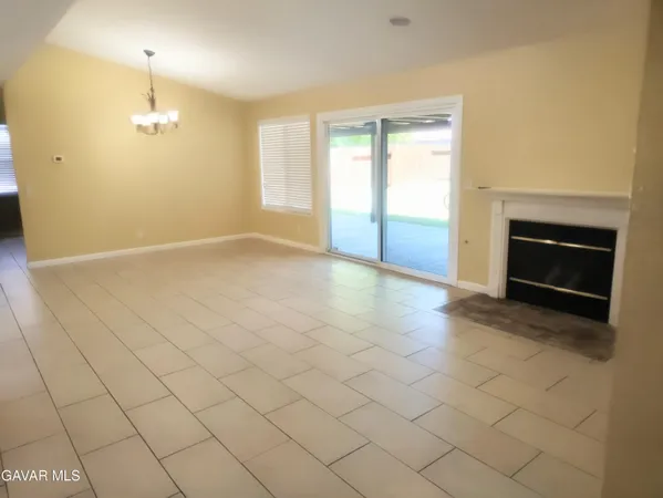 an empty room with windows and fireplace