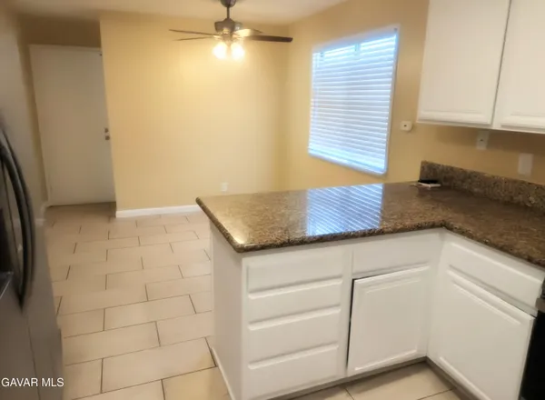a kitchen with granite countertop white cabinets and window