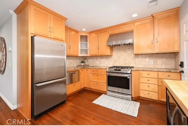 a kitchen with stainless steel appliances granite countertop a refrigerator stove and sink