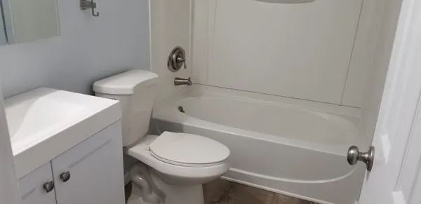 a white toilet sitting next to a bath tub