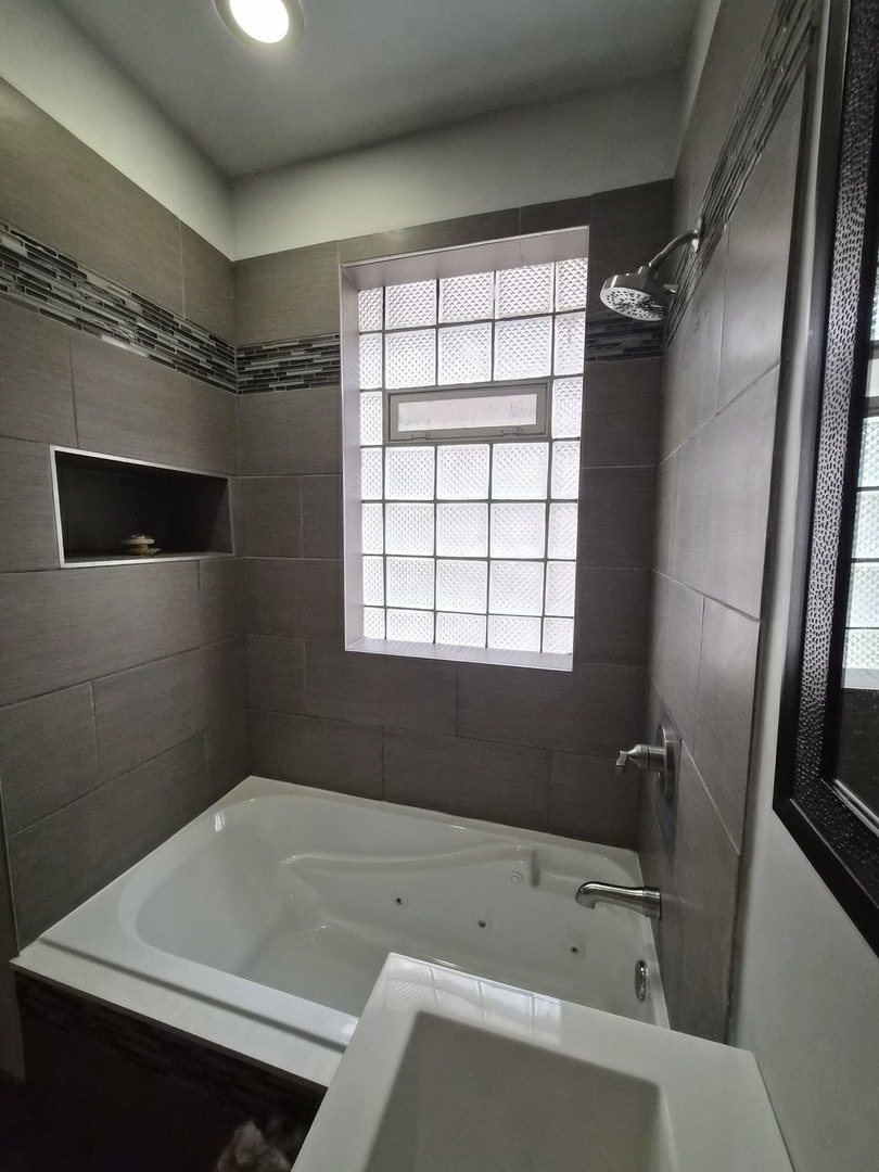 4828 South Indiana Avenue, Unit 201 Chicago, IL 60615 - Photo 13 of 17 a bathroom with a tub a sink and a window