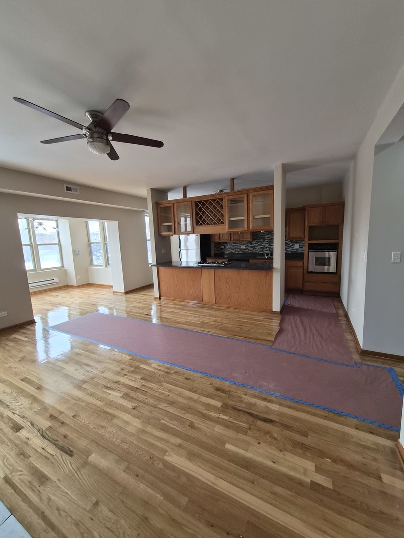 4828 South Indiana Avenue, Unit 201 Chicago, IL 60615 - Photo 7 of 17 an empty room with wooden floor and windows