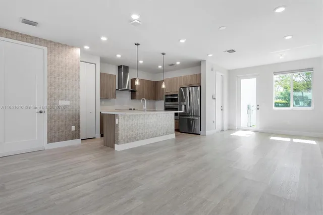 a view of kitchen with refrigerator stove and wooden floor