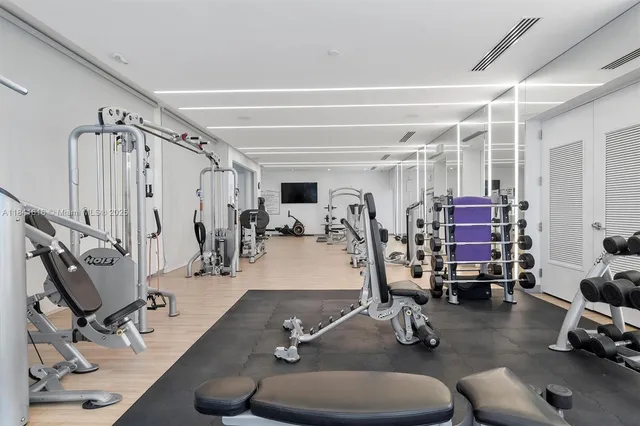 a large white building with a white sitting space and glass door