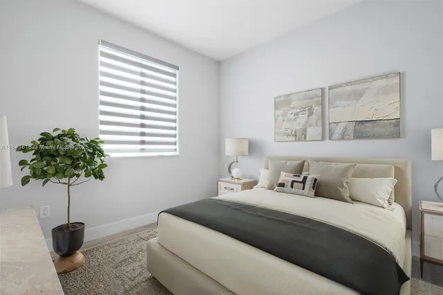 a bedroom with a bed and a potted plant