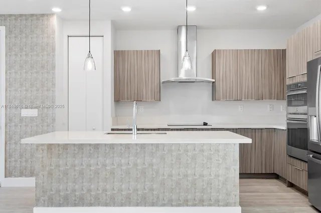 a kitchen with stainless steel appliances granite countertop a refrigerator a sink and a stove