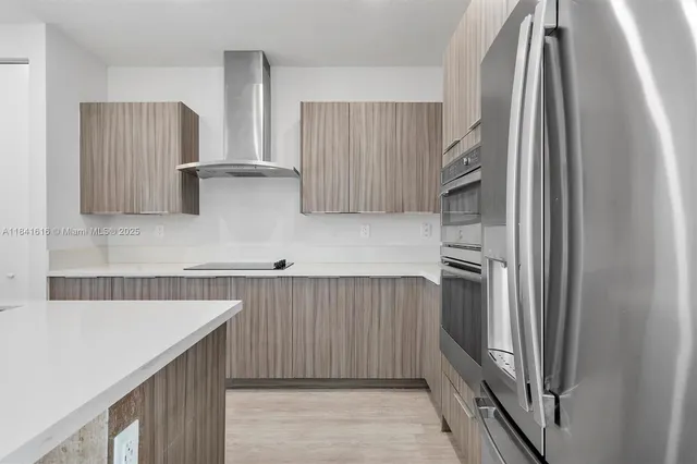 a kitchen with stainless steel appliances granite countertop a refrigerator and a sink