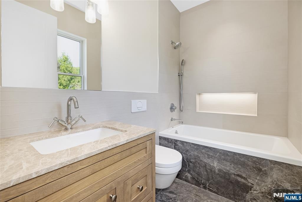 241 East Saddle River Road Saddle River, NJ 07458 - Photo 23 of 48 a bathroom with a granite countertop sink a toilet and bathtub