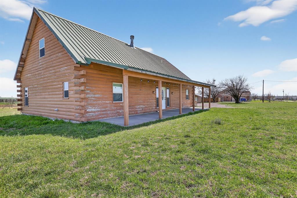 131 Hawk Ridge Decatur, TX 76234 - Photo 19 of 34 Back of property with log exterior, a metal roof, a lawn, and a porch