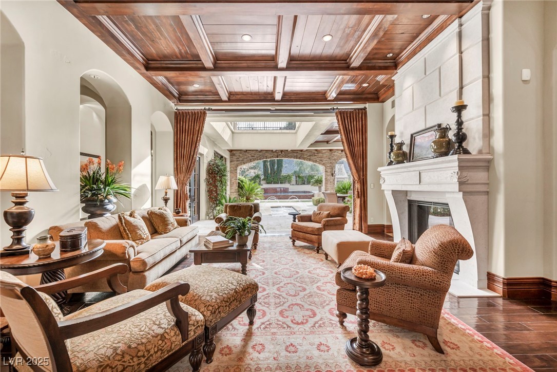 1793 Anelli Court Henderson, NV 89012 - Photo 20 of 47 Living area featuring a wooden ceiling with exposed beams, a fireplace, coffered ceiling, wood finished floors, and recessed lighting